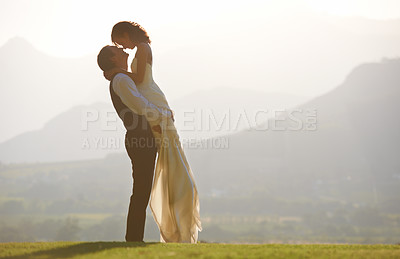Buy stock photo A groom lifting his bride in the air