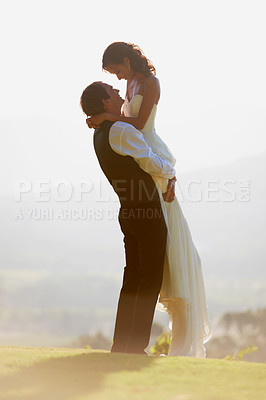 Buy stock photo Groom lifting bride, sunshine and wedding outdoor, hug with love and commitment in marriage. Man, woman and happiness, celebration and social event with trust and loyalty, romance and life partner