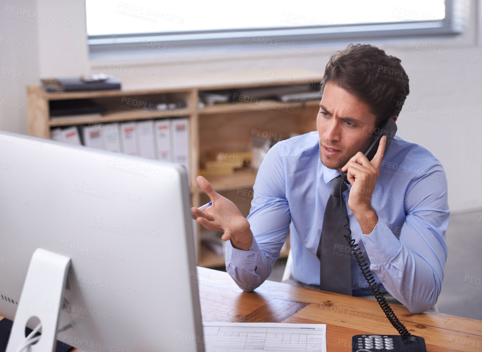 Buy stock photo Business man, phone call and stress on landline in workplace, contact and consulting or networking. Male professional, frustrated and communication or discussion, technology and confusion for info