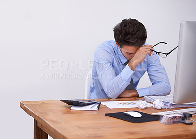 Buy stock photo Cropped shot of a tired-looking young businessman sitting in his office