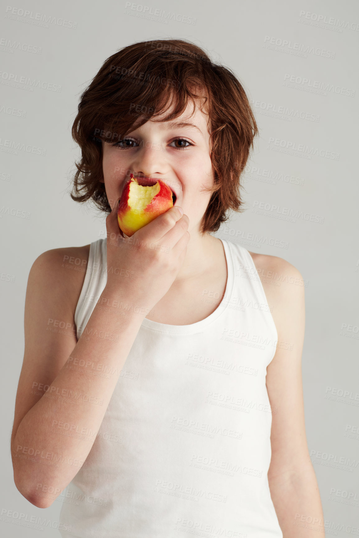 Buy stock photo Portrait of a young boy eating an apple