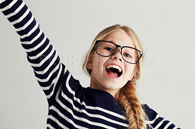 Buy stock photo Happy, excited and portrait of young girl with happiness to celebrate isolated in a white studio background. Glasses, vision and female kid smile with freedom in a strip t-shirt for child fashion