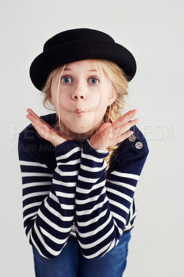 Buy stock photo Fashion, goofy and girl child in a studio with casual, cool and stylish jersey outfit and hat. Silly, comic and funny young kid model with trendy youth style and positive attitude by gray background.