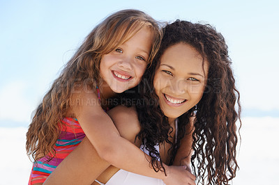 Buy stock photo A young mother and daughter smiling at the beach