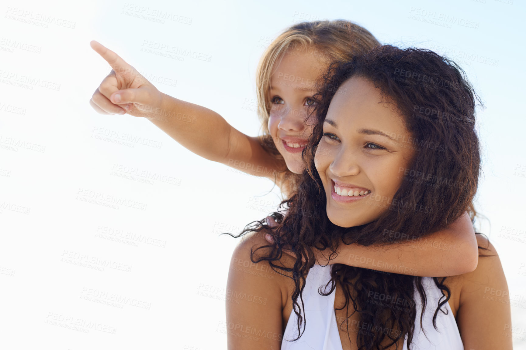 Buy stock photo A young mother piggybacking her little girl while she's pointing at something in the distance