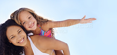 Buy stock photo A young mother carrying her daughter on her back on the beach while they both stretch out their arms