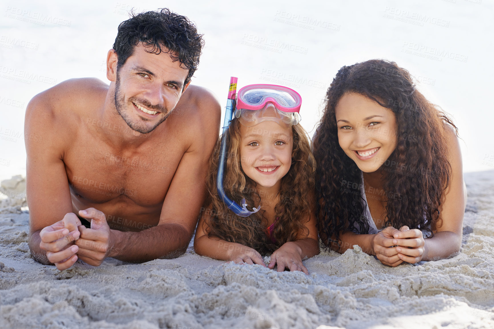 Buy stock photo Happy family, portrait and relax on beach for bonding, vacation or outdoor holiday weekend together. Face of dad, mom and kid smile lying on sand by the ocean coast for fun summer break in nature