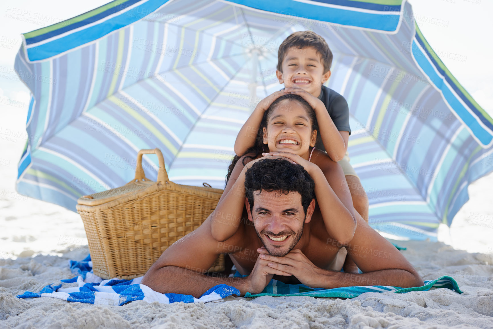 Buy stock photo Father, kids and smile in portrait on beach, summer vacation with parasol, bonding and love. People outdoor, holiday in Brazil with sand and sun, smile for travel and adventure together in nature