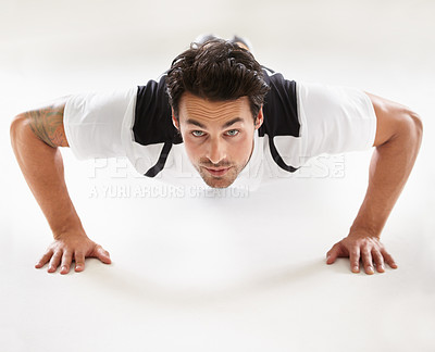 Buy stock photo Portrait of a young man doing push-ups