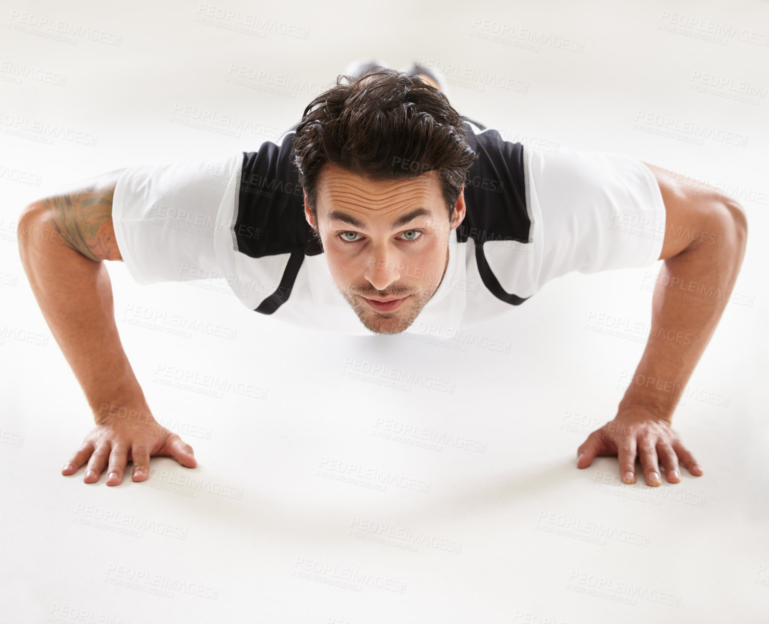 Buy stock photo Portrait of a young man doing push-ups