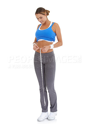 Buy stock photo Woman, stomach and measure tape in studio for diet, weight loss and health results or fitness progress. Sports person smile and check body in exercise, workout or training goals on a white background