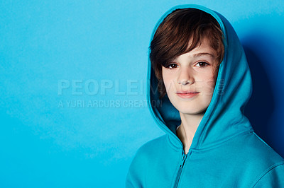 Buy stock photo Studio portrait, fashion and child in hoodie, trendy apparel or stylish clothes isolated on blue background. Mockup space, fashionable style and face of boy with warm winter fabric and casual outfit