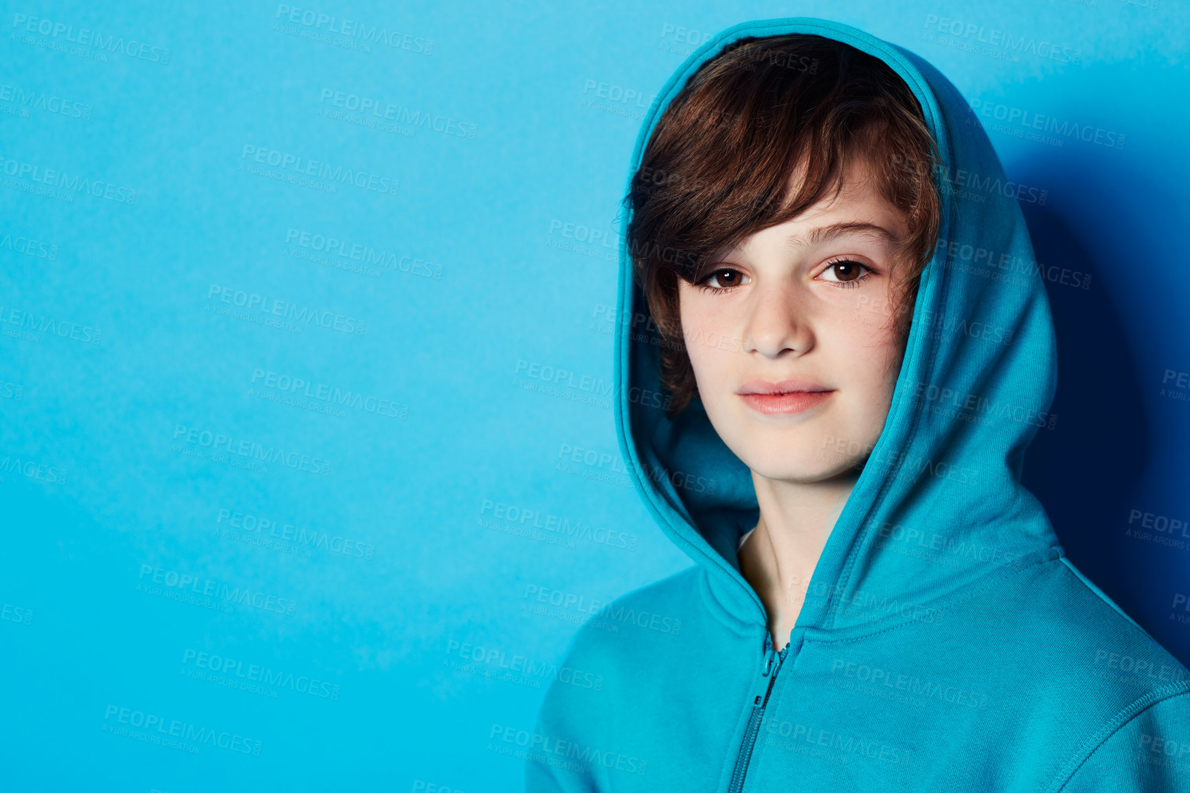 Buy stock photo Studio portrait, fashion and child in hoodie, trendy apparel or stylish clothes isolated on blue background. Mockup space, fashionable style and face of boy with warm winter fabric and casual outfit