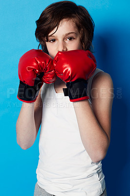 Buy stock photo Portrait of a young boy wearing boxing gloves in the studio