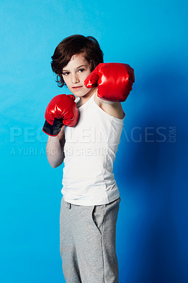 Buy stock photo Portrait, boy and kid with boxing gloves, fitness and confident fist on a blue studio background. Child development, punch and fighting with workout, combat and training with fun and mockup space