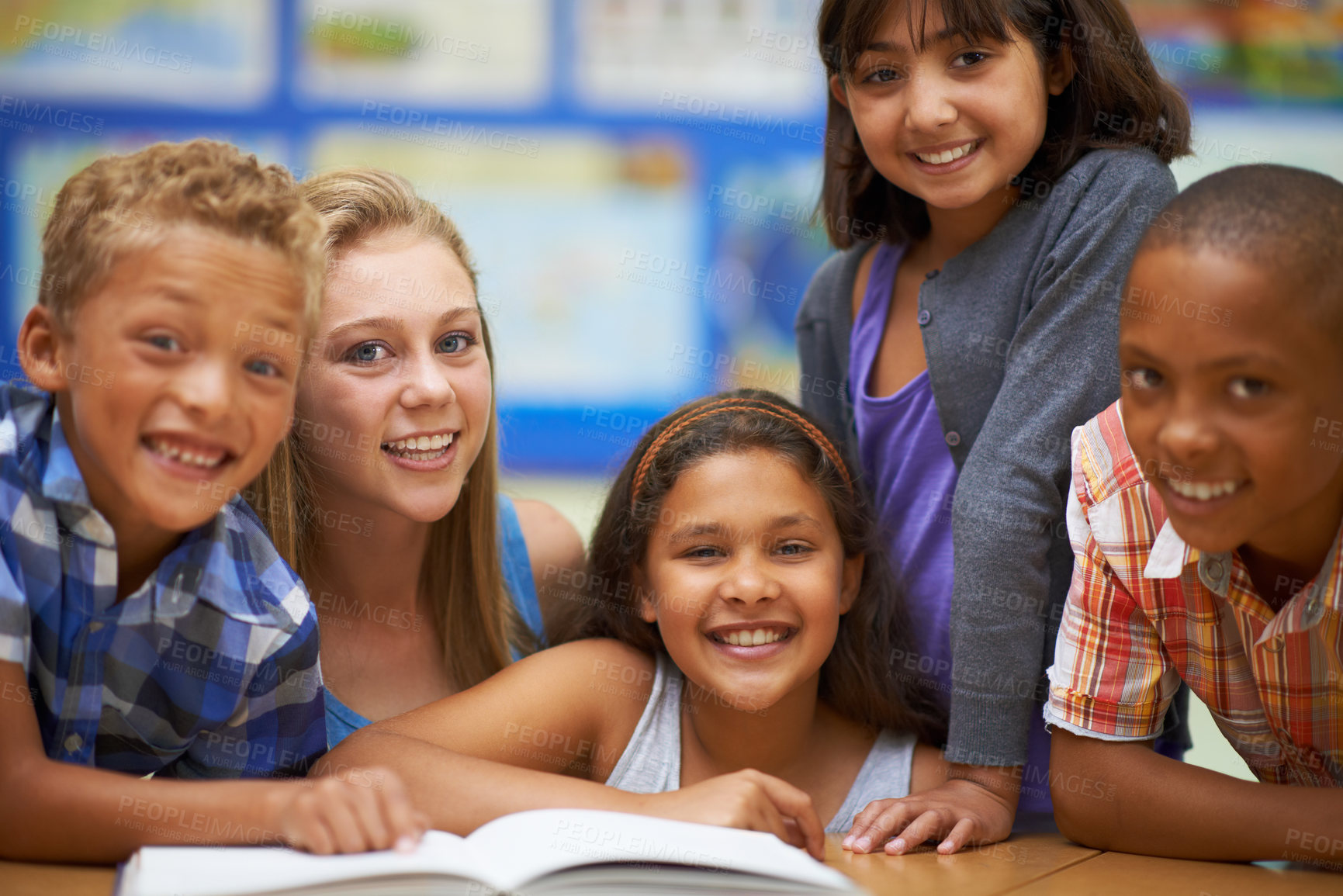 Buy stock photo Portrait of a group of pupils reading from a book in class