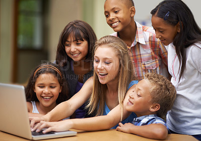Buy stock photo Children, typing on computer and learning in classroom for education, teaching and website information or group project. Happy diversity kids, students and girl with leadership on laptop at school
