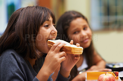 Buy stock photo Hungry girl, student and eating sandwich in classroom at school for meal, break or snack time. Young kid, person or elementary child biting bread for lunch, fiber or nutrition in class during recess