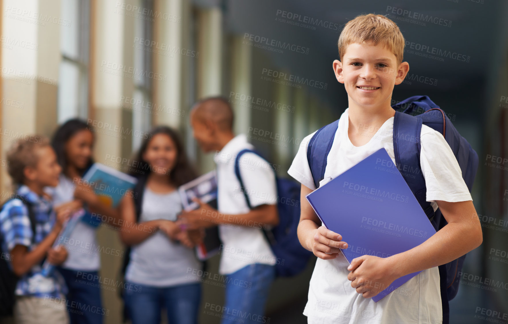Buy stock photo Boy, portrait and smile in corridor of school with backpack and books for learning, education or knowledge. Student, person and face with happy in building or hallway before class or ready to study  