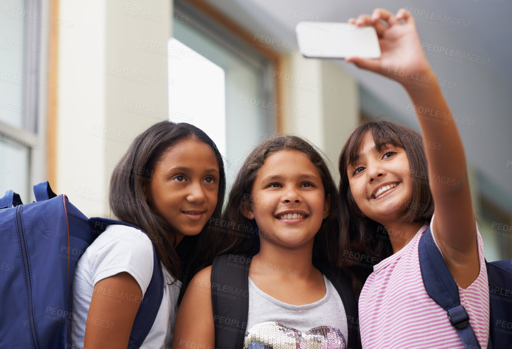 Buy stock photo Friends, children and smile for selfie in elementary school lobby for fun educational memory together. Group of students, young girls and kids taking picture for social media, photography or learning