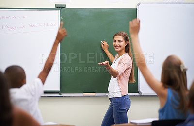 Buy stock photo Rearview shot of a group of students raising their hands during class