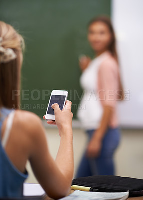 Buy stock photo Smartphone, student and texting in classroom, social media and communication in school. Female person, behind and internet connection or back, website and mobile application for games and education