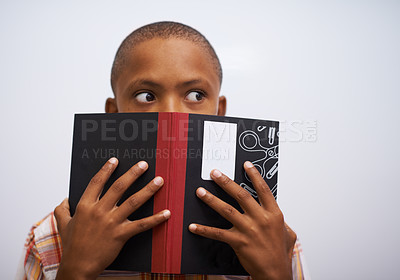 Buy stock photo Student, classroom and hide face with book to read in front for classmates, shy and learning. Elementary school, boy and prepared oral with workbook, childhood development and academic education

