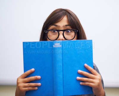 Buy stock photo Student, child and hide face with book to read in front for classroom, shy and learning. Elementary school, girl kid and prepared oral with workbook, childhood development and academic education
