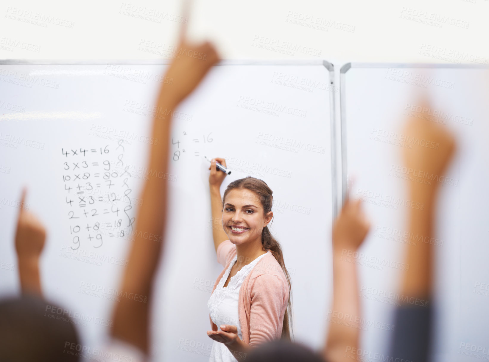 Buy stock photo A group of students raising their hands in class