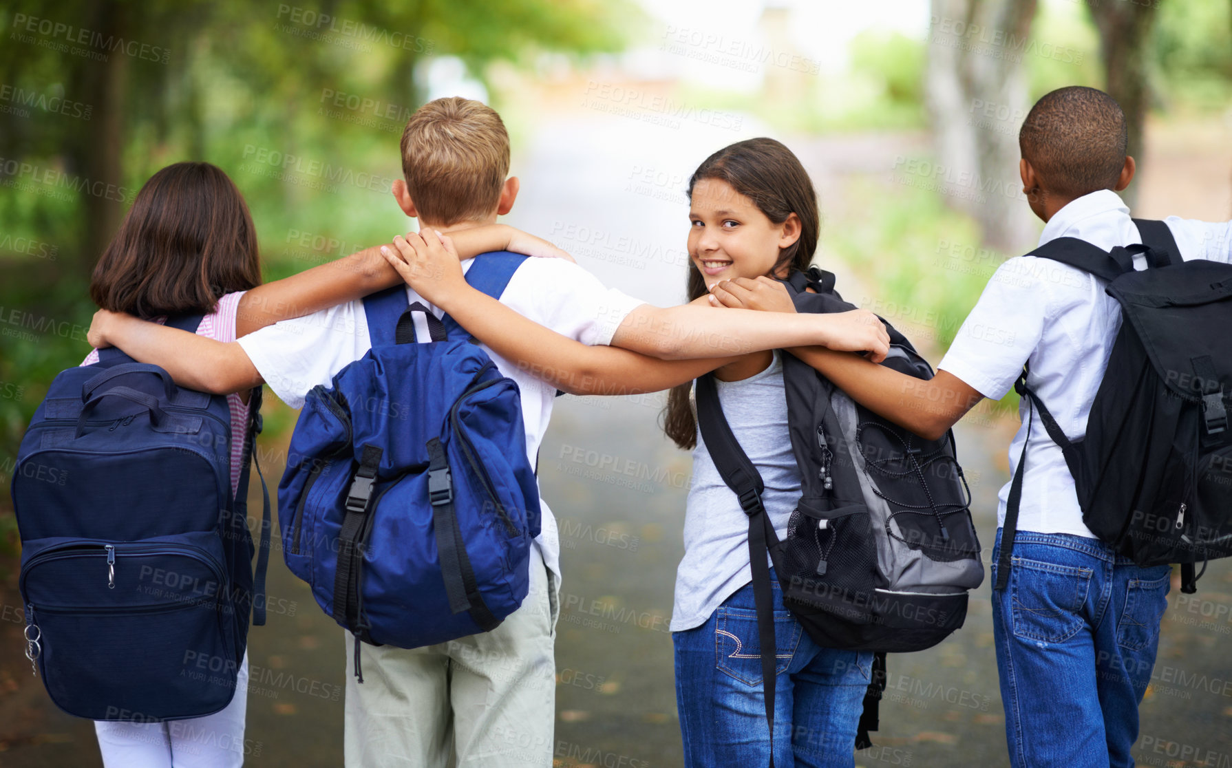 Buy stock photo Happy students, friends and hug with backpack in park for unity, teamwork or walking to school together. Rear view of young group in nature with bags for learning or education in outdoor forest