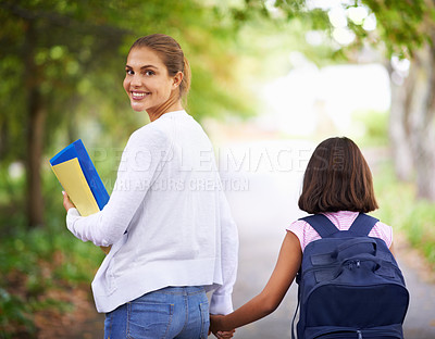 Buy stock photo Happy woman, teacher and walking student to school in park or outdoor forest for support or responsibility. Female person, educator smile and holding hands with learner, kid or young child in nature
