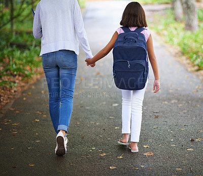 Buy stock photo Woman, teacher and walking student to school in park or outdoor forest for support or responsibility. Rear view of female person or educator holding hands with learner, kid or young child in nature