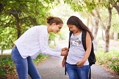 Buy stock photo Parent, helping and student with backpack in park, care and support in education development in city. Mother, child and happy on campus outdoor for love and tying bag for learning  in middle school
