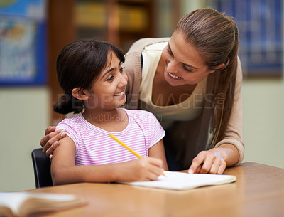 Buy stock photo Study, education or learning with a student and teacher in a classroom together for writing or child development. School, scholarship and teaching with a woman educator helping a girl child in class