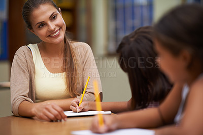 Buy stock photo Happy teacher, students and writing in class for education, learning or tutoring at school. Woman, mentor or educator smile for helping kids or children with books in study, library or classroom