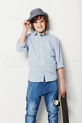 Buy stock photo Cute preteen boy wearing trendy attire and holding a skateboard while isolated on white