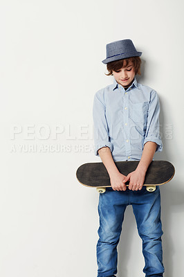 Buy stock photo Skateboard, young boy with a hat and mockup in studio background with space. Trendy fashion or casual wear, confident or cool and isolated person posing for clothing advertisement in backdrop