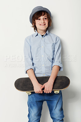 Buy stock photo Child, boy and skateboard for fashion in studio, cool clothing and confidence by white background. Happy male person, kid and hat by backdrop or pride for activity, smile and trendy outfit or sports