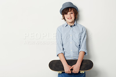 Buy stock photo Child, boy and skateboard for portrait in studio, cool clothing and confidence by white background. Happy male person, kid and hat by mockup or pride for activity, smile and trendy fashion or sport