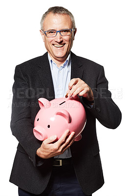 Buy stock photo Studio portrait of a mature businessman putting coins into a piggybank