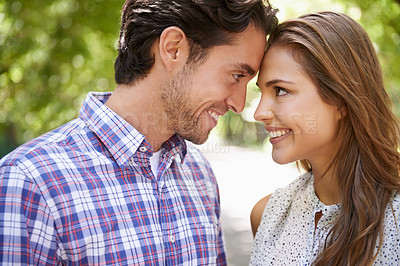 Buy stock photo Face, love and couple in park with forehead, touch and bonding against a blurred background. Happy, embrace and man with woman in nature, smile and excited on Valentines Day for relationship and date