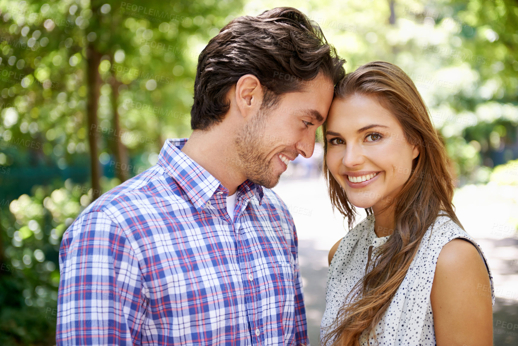 Buy stock photo Portrait, couple and hug in park with forehead, touch and bonding against a blurred background. Face, embrace and man with woman in nature, smile and excited for reunion, relationship or togetherness