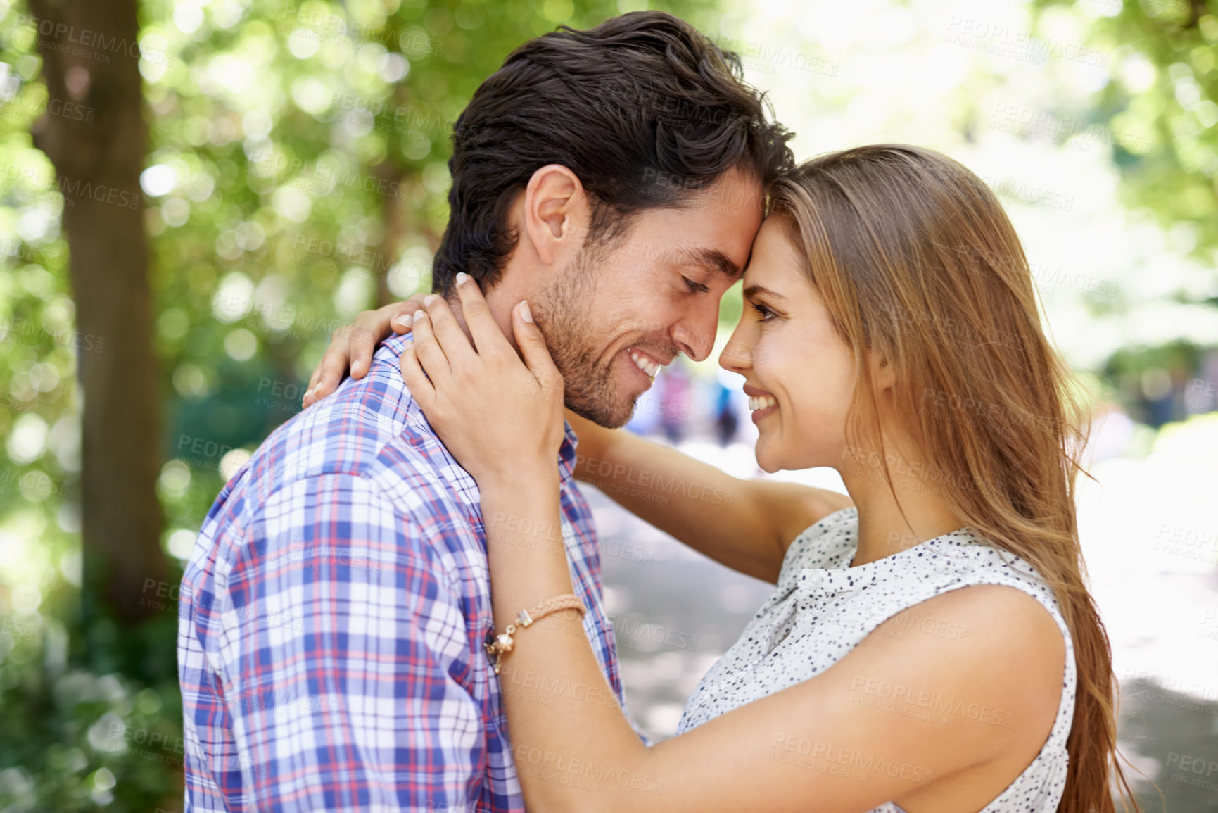 Buy stock photo Happy, couple and hug in park with forehead, touch and bonding against a blurred background. Face, embrace and man with woman in nature, smile and excited for reunion, relationship and togetherness