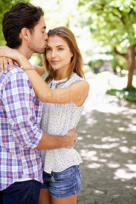 Buy stock photo Couple hug, bonding and forehead kiss on love date, valentines day or romance in nature break, park or relax garden. Man, happy woman and kissing head in trust, security embrace or thank you support