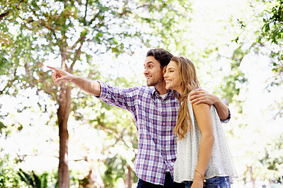 Buy stock photo Couple, park and date of a woman and man together with love, care and hug in nature. Green trees, sunshine and happy people outdoor excited by pointing in the sun with happiness and good mood