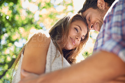 Buy stock photo Love, nature and couple hug in park with trees while on romantic date for valentines day, from below. Romance, relationship and man with woman in garden together with happy smile and loving touch.