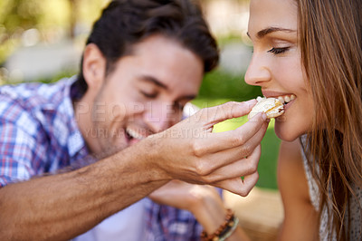 Buy stock photo Couple picnic, romantic and feeding on grass lawn with happiness, kindness and love on valentines date. Man, woman and eating together at nature park with food for bonding, romance and care by trees