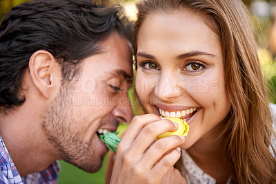 Buy stock photo Man, woman and picnic portrait with candy feeding on lawn with happiness, kindness or valentines day love. Happy couple, macaroon or together at nature park with sweets for bonding, romance or care