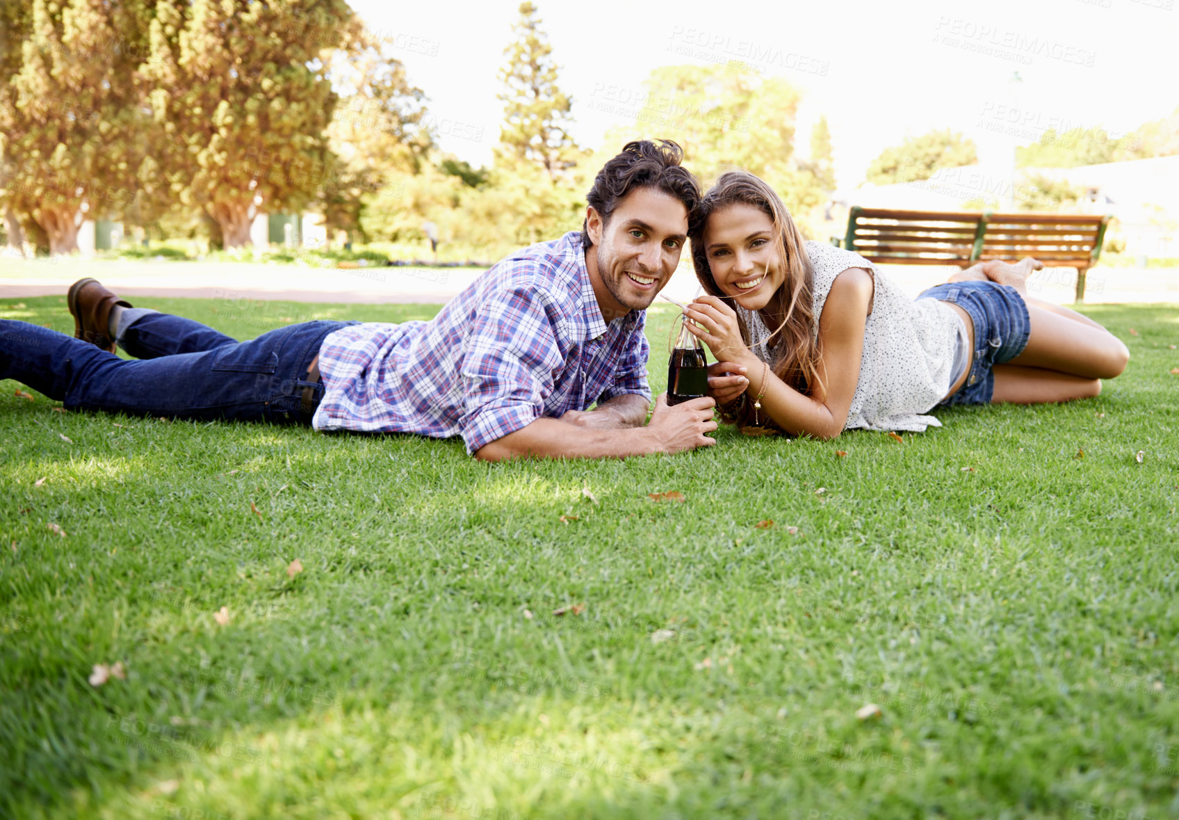 Buy stock photo Happy couple, park and valentines day date portrait with a drink on grass for love, bonding and time together. Smile of a young man and woman in nature for a summer picnic with a cola bottle outdoor