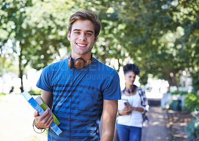 Buy stock photo Portrait of a good looking student walking to college with his books in his hand